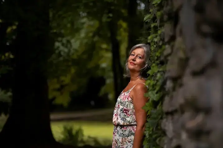 Martina Sedlmair lehnt im Abendlicht an einer alten Steinmauer